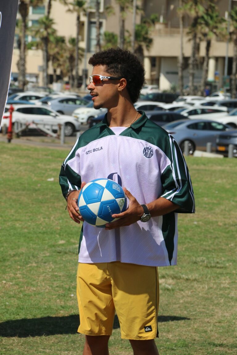 שחקן מחזיק כדור פוצ'יבולי TATU BOLA כחול-לבן לפני מעגל